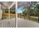 View of a large new wooden covered porch with railings overlooking the backyard and wooden fence at 358 Prevo Dr, Apopka, FL 32712