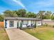 Charming single-story home featuring a white exterior with bold blue trim and a cozy front porch seating area at 358 Prevo Dr, Apopka, FL 32712