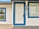 Close-up of the front door with blue trim and modern exterior light fixture at 358 Prevo Dr, Apopka, FL 32712