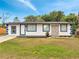 Inviting single-story home showcasing crisp white stucco with vibrant blue trim and a cozy front yard at 358 Prevo Dr, Apopka, FL 32712
