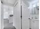 Hallway view to kitchen and bathroom with white cabinets, closets, and gray countertops at 358 Prevo Dr, Apopka, FL 32712