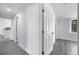 Hallway with gray wood floors leading to rooms with white doors and trim at 358 Prevo Dr, Apopka, FL 32712