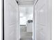 Hallway view to a bright kitchen with white cabinets and gray countertops at 358 Prevo Dr, Apopka, FL 32712