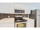 This kitchen features stainless steel appliances, white cabinets, and stylish backsplash, combining functionality with modern design at 3621 Conroy Rd # 738, Orlando, FL 32839