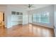 Bright living area featuring hardwood floors, built-in shelving, and a sliding door to a balcony at 3621 Conroy Rd # 738, Orlando, FL 32839