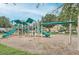 Community playground with green slides and various climbing structures surrounded by trees at 3621 Conroy Rd # 738, Orlando, FL 32839