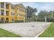 Exterior view of a sand volleyball court with net and well-manicured green surroundings at 3621 Conroy Rd # 738, Orlando, FL 32839