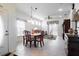 Bright dining area with decorative chandelier, tile floors and abundant natural light from large windows and sliding door at 401 Harbor Winds Ct, Winter Springs, FL 32708