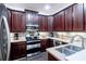 Modern kitchen boasting dark wood cabinets, stainless steel appliances, granite countertops and tile backsplash at 401 Harbor Winds Ct, Winter Springs, FL 32708