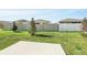 Spacious backyard with healthy green grass and a partial view of neighboring homes at 4224 Pebbles Throw Dr, Kissimmee, FL 34746