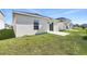 Spacious backyard features a sliding glass door, small patio, and an expansive lawn perfect for outdoor activities at 4224 Pebbles Throw Dr, Kissimmee, FL 34746