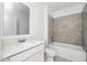 A well-lit bathroom featuring a modern vanity, toilet, and tiled shower-tub combo at 4224 Pebbles Throw Dr, Kissimmee, FL 34746