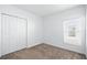 A well-lit bedroom featuring a window, closet, and neutral carpet at 4224 Pebbles Throw Dr, Kissimmee, FL 34746