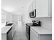 Bright kitchen with stainless steel appliances and a view of the living area at 4224 Pebbles Throw Dr, Kissimmee, FL 34746