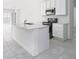 Modern, all-white kitchen featuring an island with a sink and plenty of counter space at 4224 Pebbles Throw Dr, Kissimmee, FL 34746