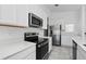 A modern kitchen featuring stainless steel appliances, white cabinets, and sleek countertops at 4224 Pebbles Throw Dr, Kissimmee, FL 34746