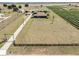 Aerial view of a large property with a long driveway leading to the home, green space, and green crops at 4400 Walker Lake Rd, Bartow, FL 33830