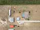 Aerial view of the property featuring a pool, home, and several detached buildings and open green space at 4400 Walker Lake Rd, Bartow, FL 33830