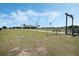 A ranch property entrance with a black gate featuring white lettering and a windmill in the distance at 4400 Walker Lake Rd, Bartow, FL 33830
