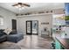 Open-concept living area with hardwood floors, a gray couch and access to the kitchen and the lanai at 4400 Walker Lake Rd, Bartow, FL 33830