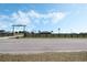 A long driveway leads to a house with a windmill and a ranch entrance with longhorn skull overhead at 4400 Walker Lake Rd, Bartow, FL 33830