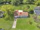 Aerial view of the home with a long driveway, and a large, green lawn surrounded by mature trees at 51 Park Ln, Debary, FL 32713