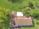 Overhead view of a home with brown roof, white patio and manicured lawn with mature trees at 51 Park Ln, Debary, FL 32713