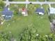 Aerial view shows the property with green lawn, mature trees, a long driveway, and a neighboring pool at 51 Park Ln, Debary, FL 32713