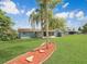 Landscaped backyard with vibrant greenery and a walkway lined with mulch at 51 Park Ln, Debary, FL 32713