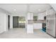 Open-concept kitchen boasts white cabinets, stainless steel appliances, and access to outdoor space at 51 Park Ln, Debary, FL 32713