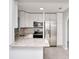 Bright and modern kitchen featuring white cabinets, stainless steel appliances, and granite countertops at 51 Park Ln, Debary, FL 32713