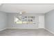 Bright living room featuring grey tile flooring, a ceiling fan, and a large window at 51 Park Ln, Debary, FL 32713