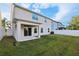 The backyard includes a grassy lawn, white fence, covered patio and view of the home's exterior at 611 Marsh Reed Dr, Winter Garden, FL 34787