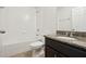 This bathroom showcases a tub with shower, dark vanity with granite countertop, and tile flooring at 611 Marsh Reed Dr, Winter Garden, FL 34787