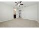Bright bedroom with neutral carpet, ceiling fan, and a door leading to the bathroom at 611 Marsh Reed Dr, Winter Garden, FL 34787