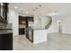 Stylish kitchen boasts granite counters, stainless appliances, dark cabinetry, mosaic backsplash, and an island overlooking living area at 611 Marsh Reed Dr, Winter Garden, FL 34787