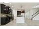 Contemporary kitchen with dark cabinets, modern stainless appliances, granite countertops, mosaic backsplash, and a large island at 611 Marsh Reed Dr, Winter Garden, FL 34787