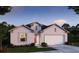 Charming single-story home featuring a two-car garage, well-manicured lawn, and neutral color palette at 6635 Lullaby Way, Mascotte, FL 34753