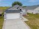 Stylish gray home boasts a manicured lawn, two-car garage, and well-maintained landscaping at 721 Rollins Dr, Davenport, FL 33837