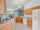 Open kitchen with tile floors, wood cabinets, and views of the dining room at 721 Rollins Dr, Davenport, FL 33837