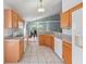 Well-lit kitchen with tile floors, wood cabinets, and views of the dining and living areas at 721 Rollins Dr, Davenport, FL 33837
