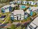 Aerial view of condo community featuring modern architecture, a playground, swimming pool, and lush landscaping at 7770 Sandy Ridge Dr # 207, Reunion, FL 34747