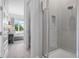 Modern bathroom featuring a walk-in shower with gray tiling and glass door in a bright and airy setting at 7770 Sandy Ridge Dr # 207, Reunion, FL 34747