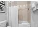 Cozy bathroom with shower featuring a white tub, white tiling, and linen storage at 7770 Sandy Ridge Dr # 207, Reunion, FL 34747
