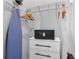 Neat closet with white dresser, safe, and mounted ironing board offering practical storage solutions at 7770 Sandy Ridge Dr # 207, Reunion, FL 34747