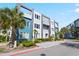 Modern three-story building with a blue and grey exterior surrounded by small palm trees and manicured landscaping at 7770 Sandy Ridge Dr # 207, Reunion, FL 34747