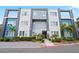 Modern three-story condo building with a blue and grey exterior, well-maintained landscaping, and a clearly marked entrance at 7770 Sandy Ridge Dr # 207, Reunion, FL 34747