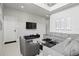 Spacious living room featuring a comfortable gray sofa and large television at 7770 Sandy Ridge Dr # 207, Reunion, FL 34747