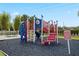 Community playground with climbing wall, slide, and picnic table on a black rubber surface at 7770 Sandy Ridge Dr # 207, Reunion, FL 34747