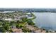 Panoramic aerial view showcases homes by the lake, tennis court, and commercial shopping area nearby at 8125 Via Rosa, Orlando, FL 32836